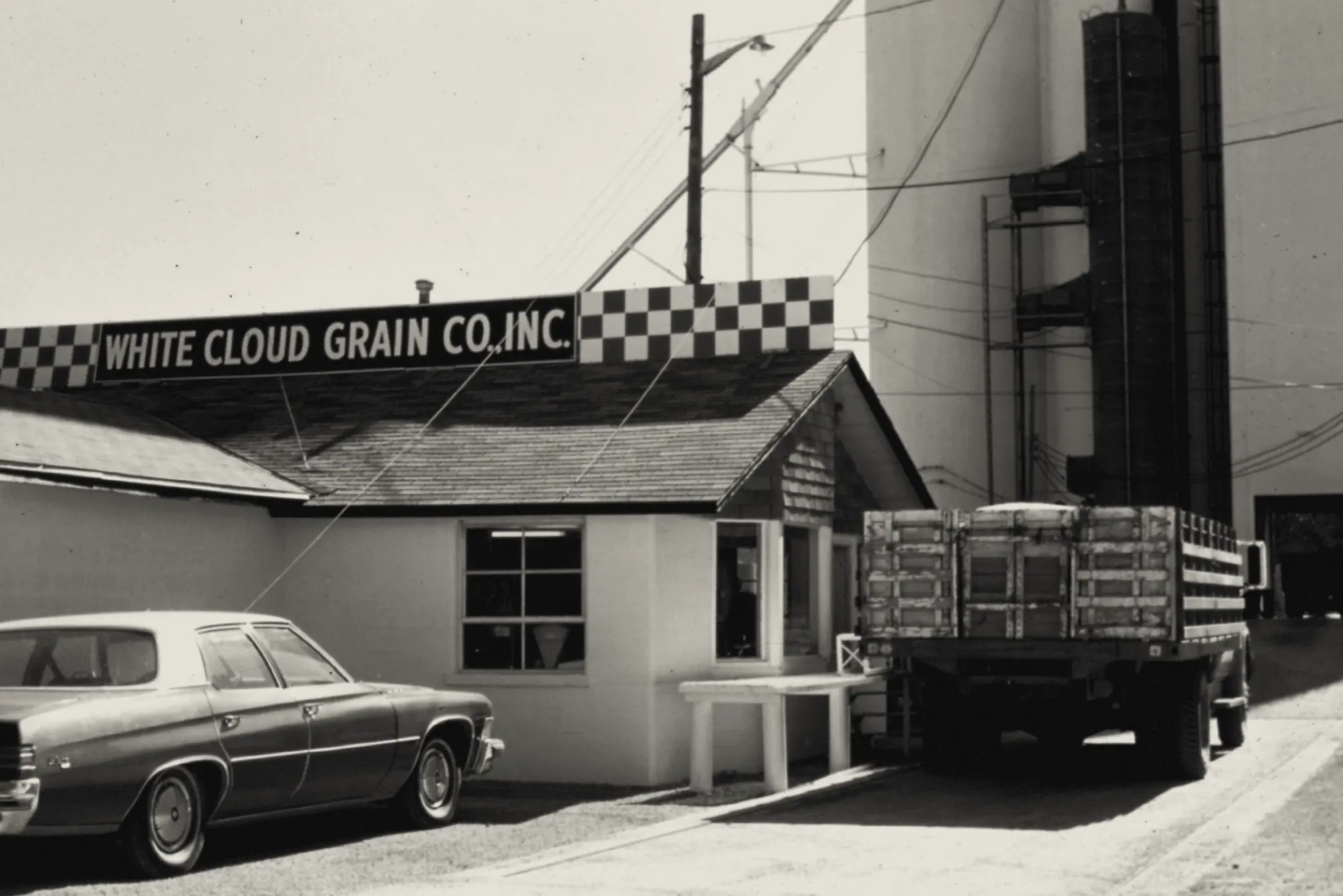 The White Cloud Grain Co. scale house and elevator, with a grain truck at the window, in White Cloud, Kansas